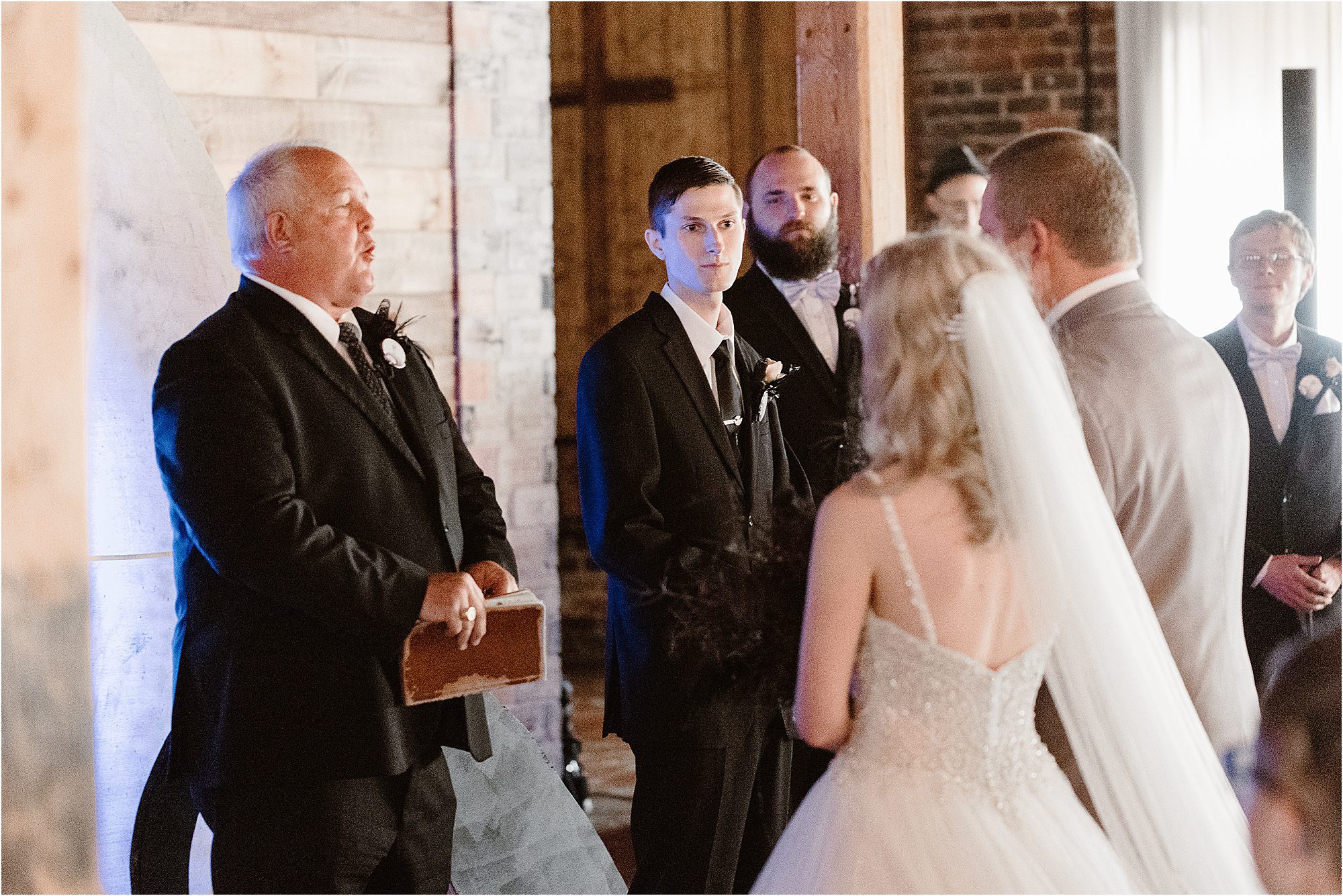 groom watching bride walk down aisle at Old Woolen Mill in Cleveland, TN