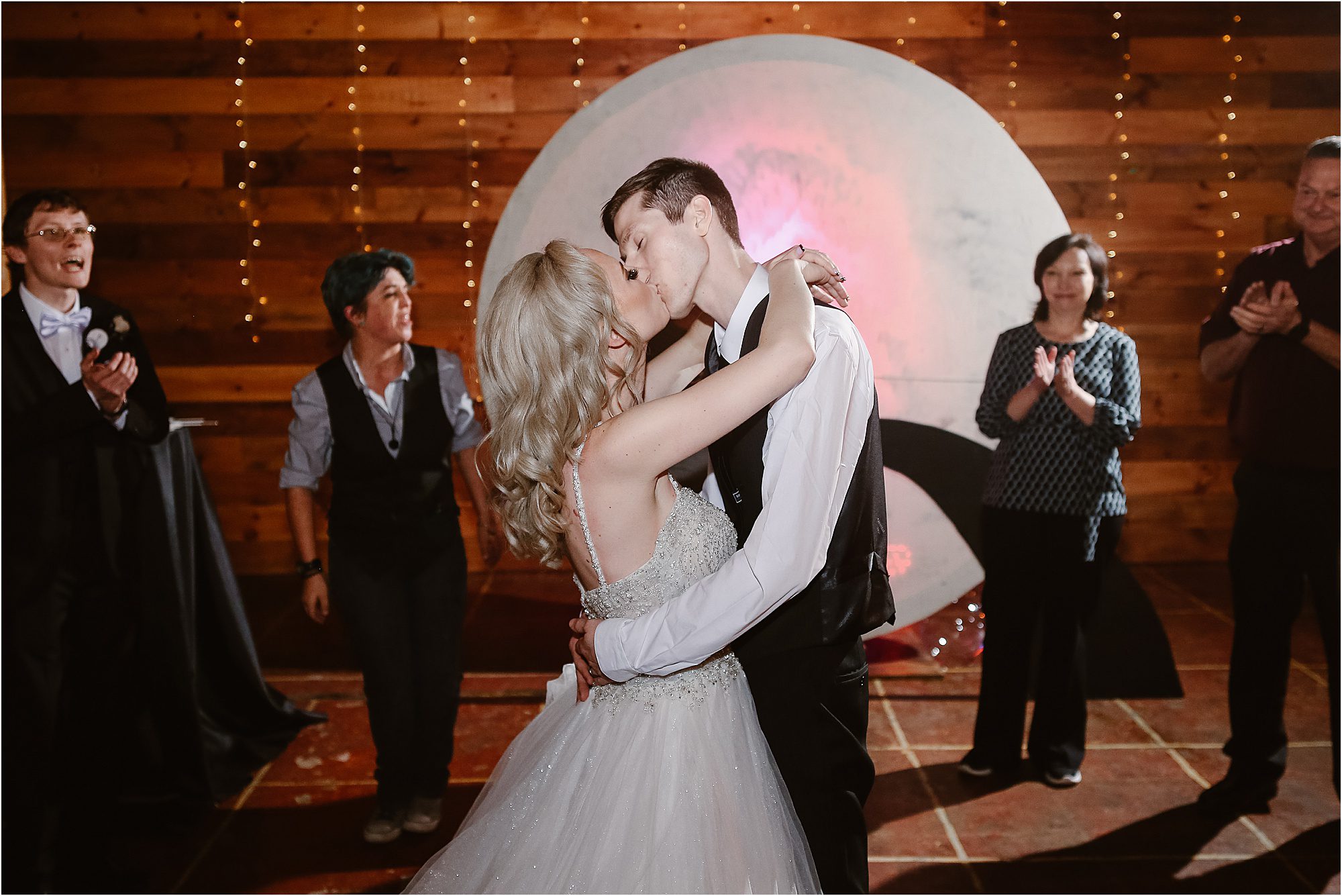 bride and groom kiss on dance floor at wedding reception