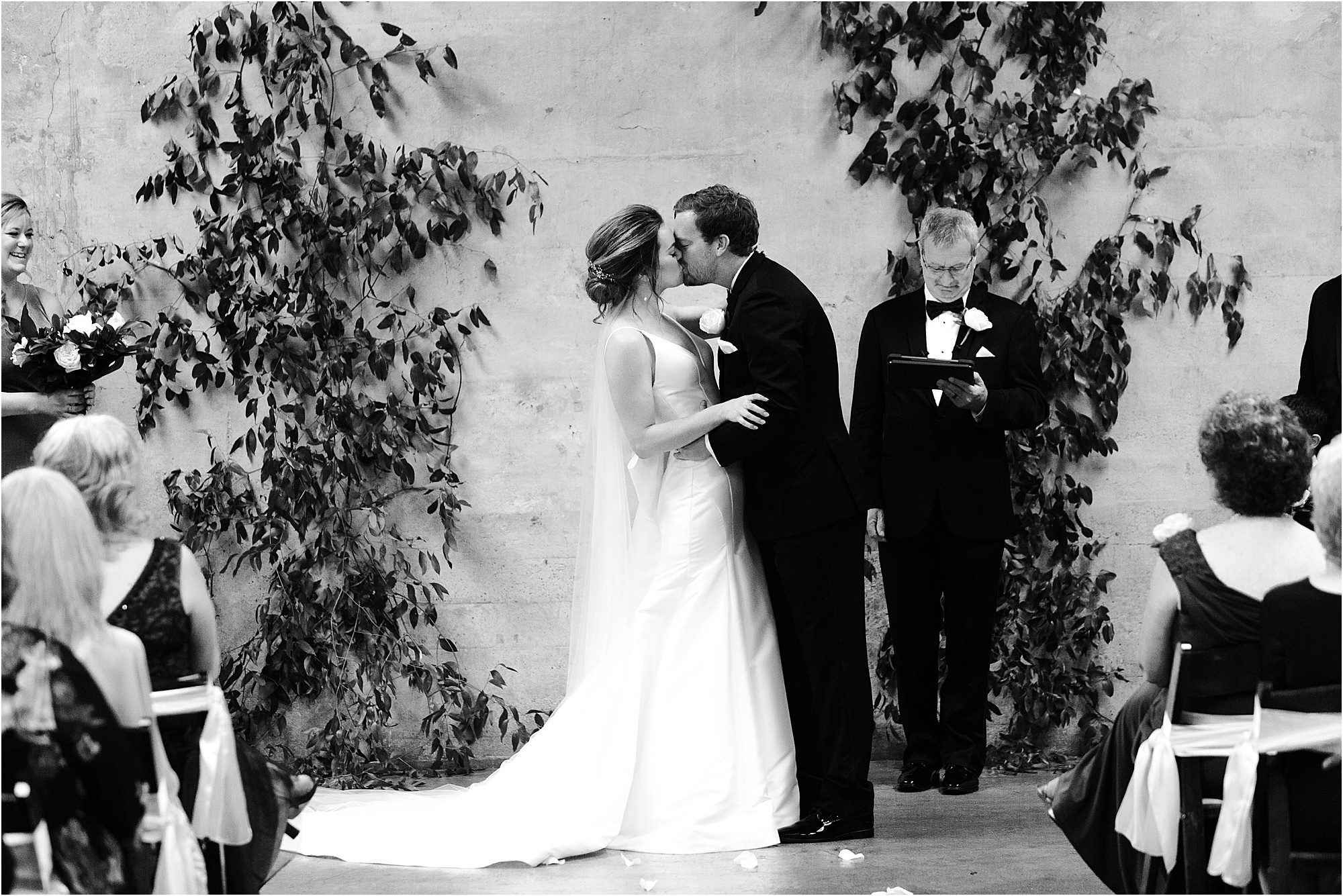 first kiss at wedding ceremony in black and white