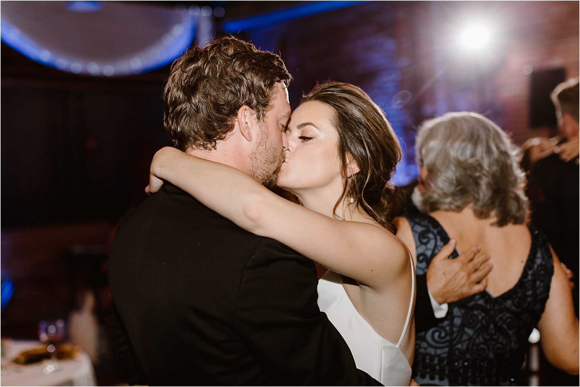 bride and groom kiss during dancing at wedding reception