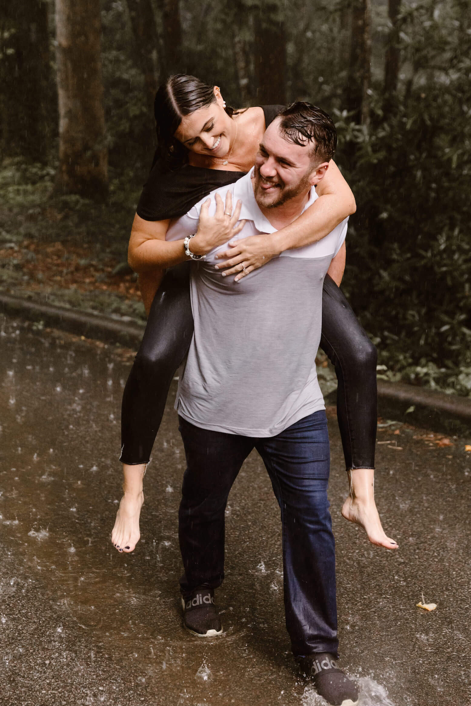woman piggyback on man during rainstorm in the Smokies by Erin Morrison Photography