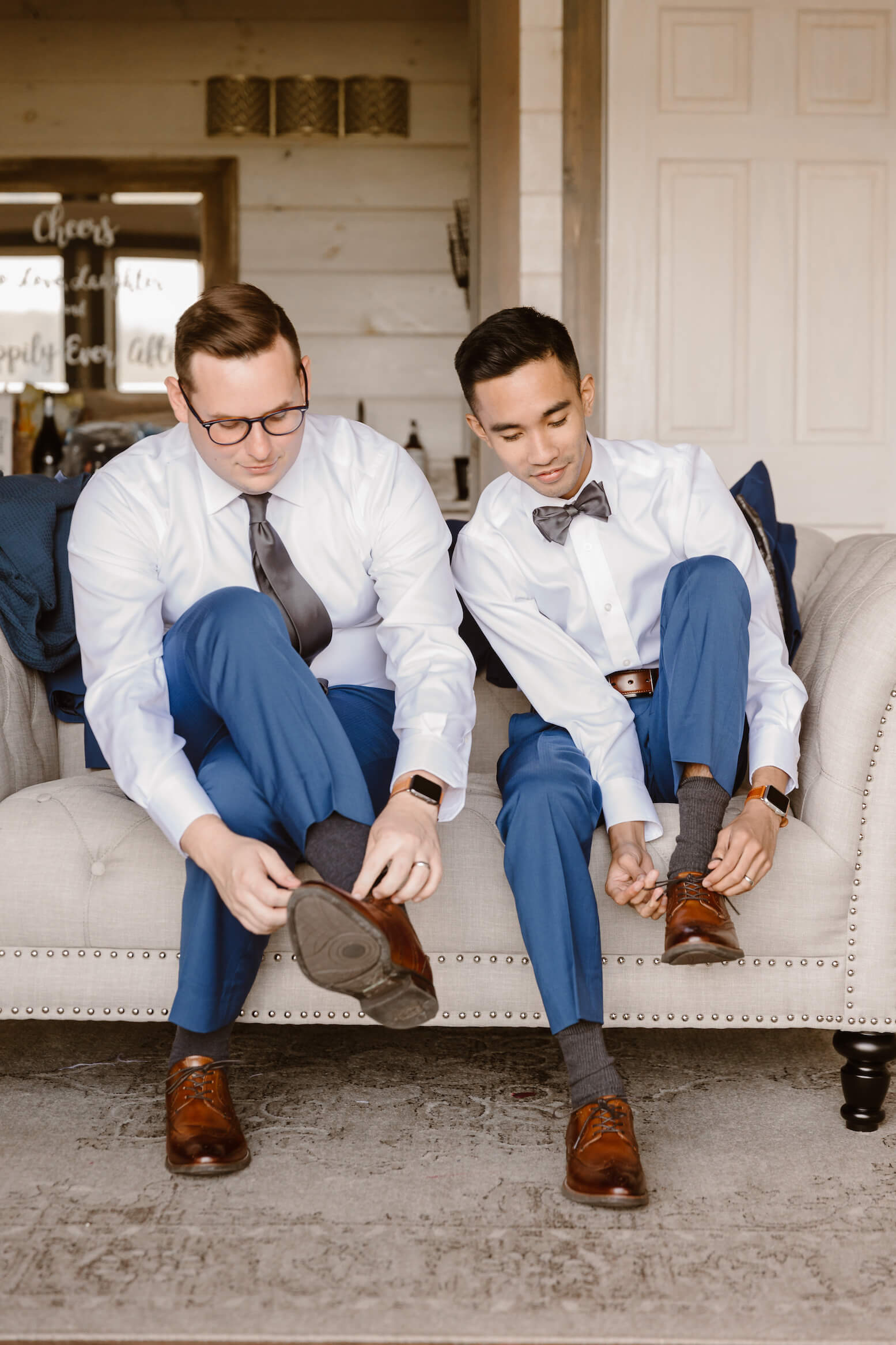 two men tie shoes during lgbt wedding with Erin Morrison Photography