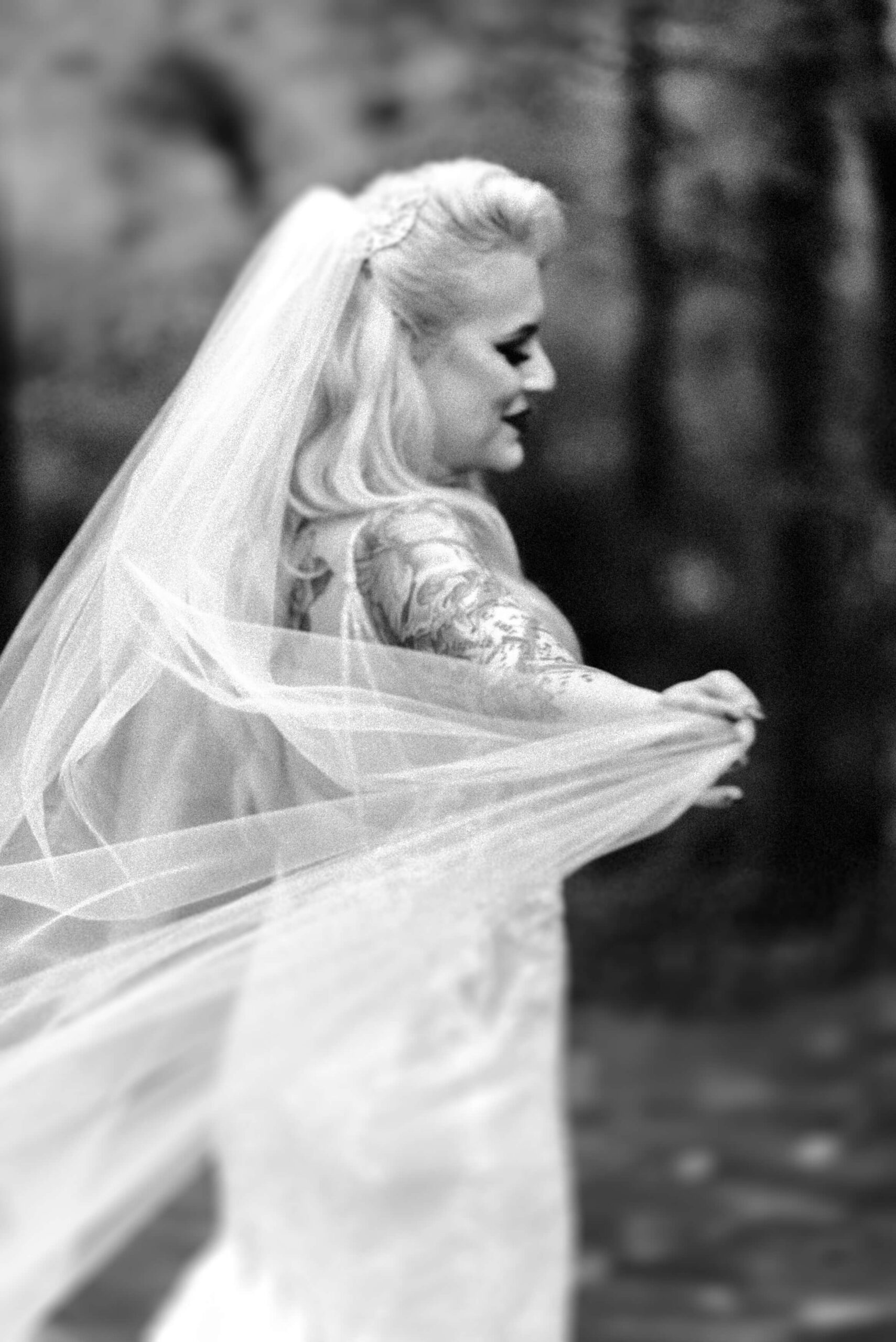 black and white photo of bride dancing with veil