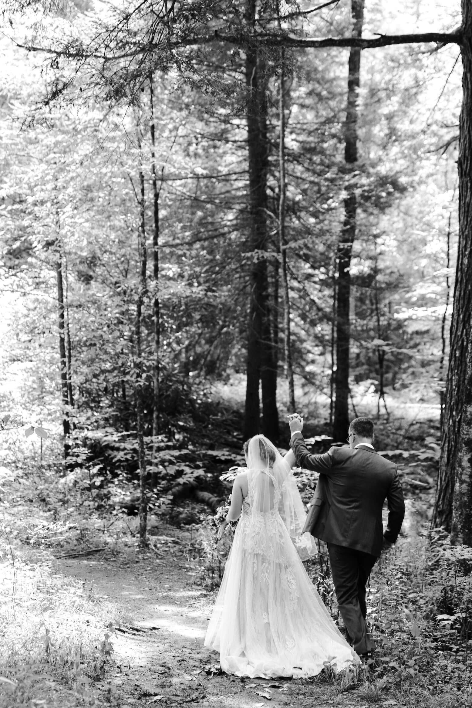 bride and groom holding hands in forest at their elopement in Elkmont in the Smoky Mountains