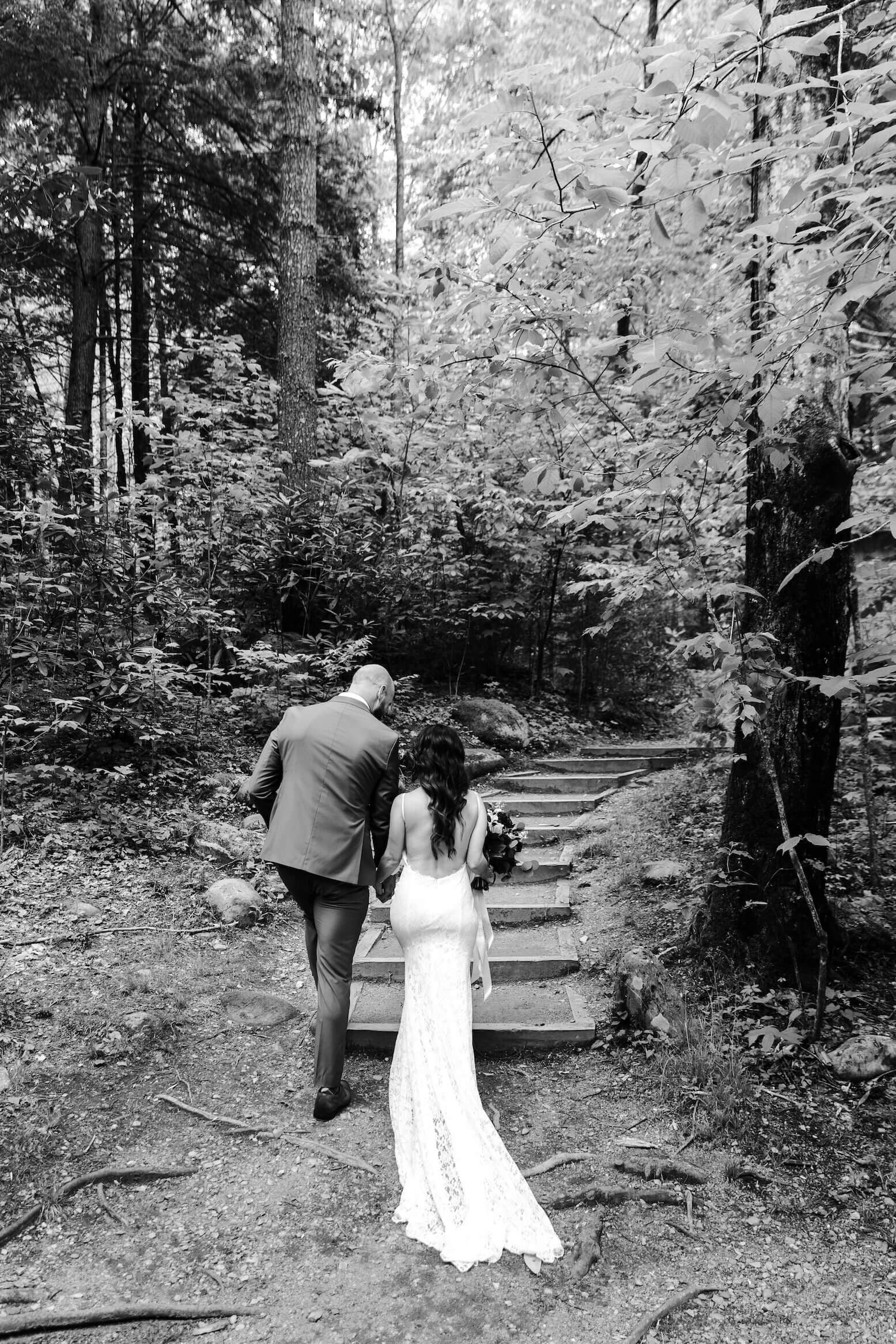 bride and groom walk up the stairs in the forest at their mountain elopement by Erin Morrison Photography