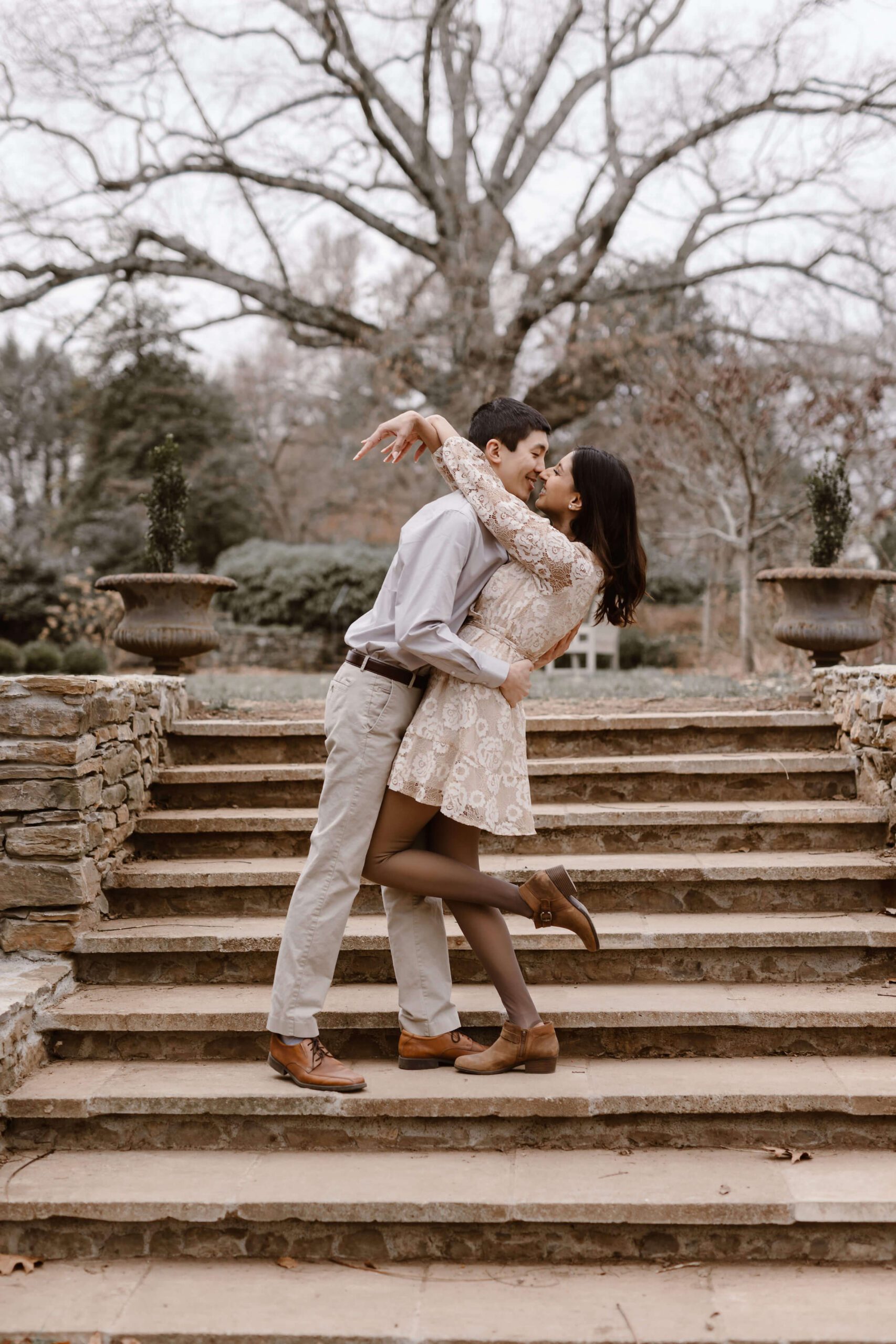 man dipping woman and kissing her on the stairs at engagement session by Erin Morrison Photography