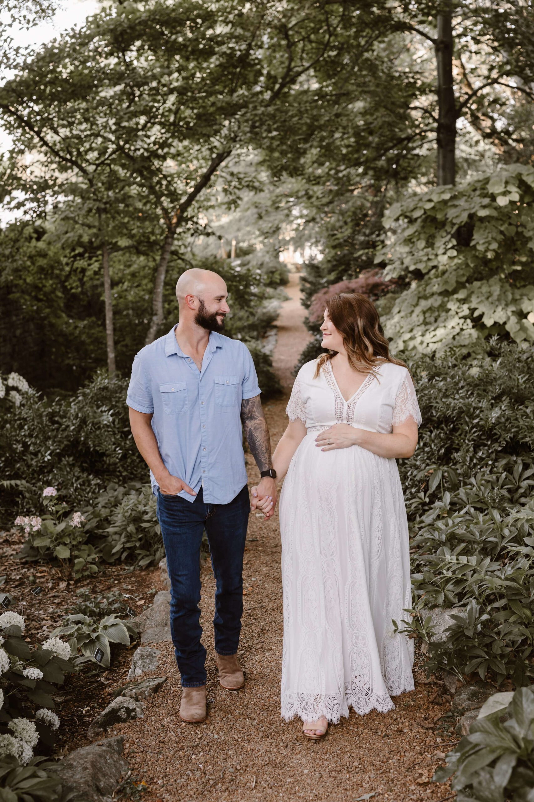 man in blue shirt walking with pregnant woman during family portfolio session in Knoxville