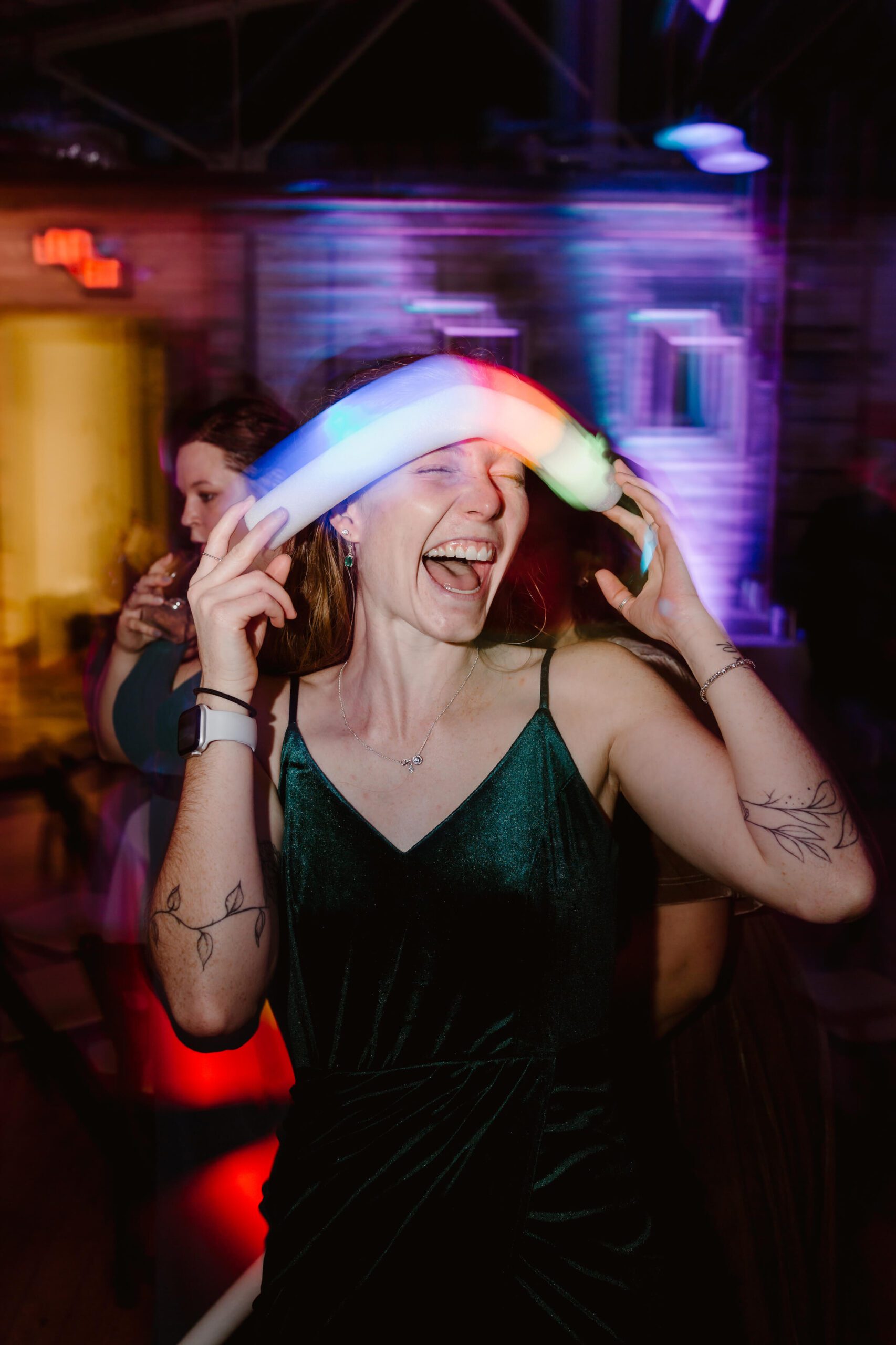 girl laughing while holding glow stick over her forehead