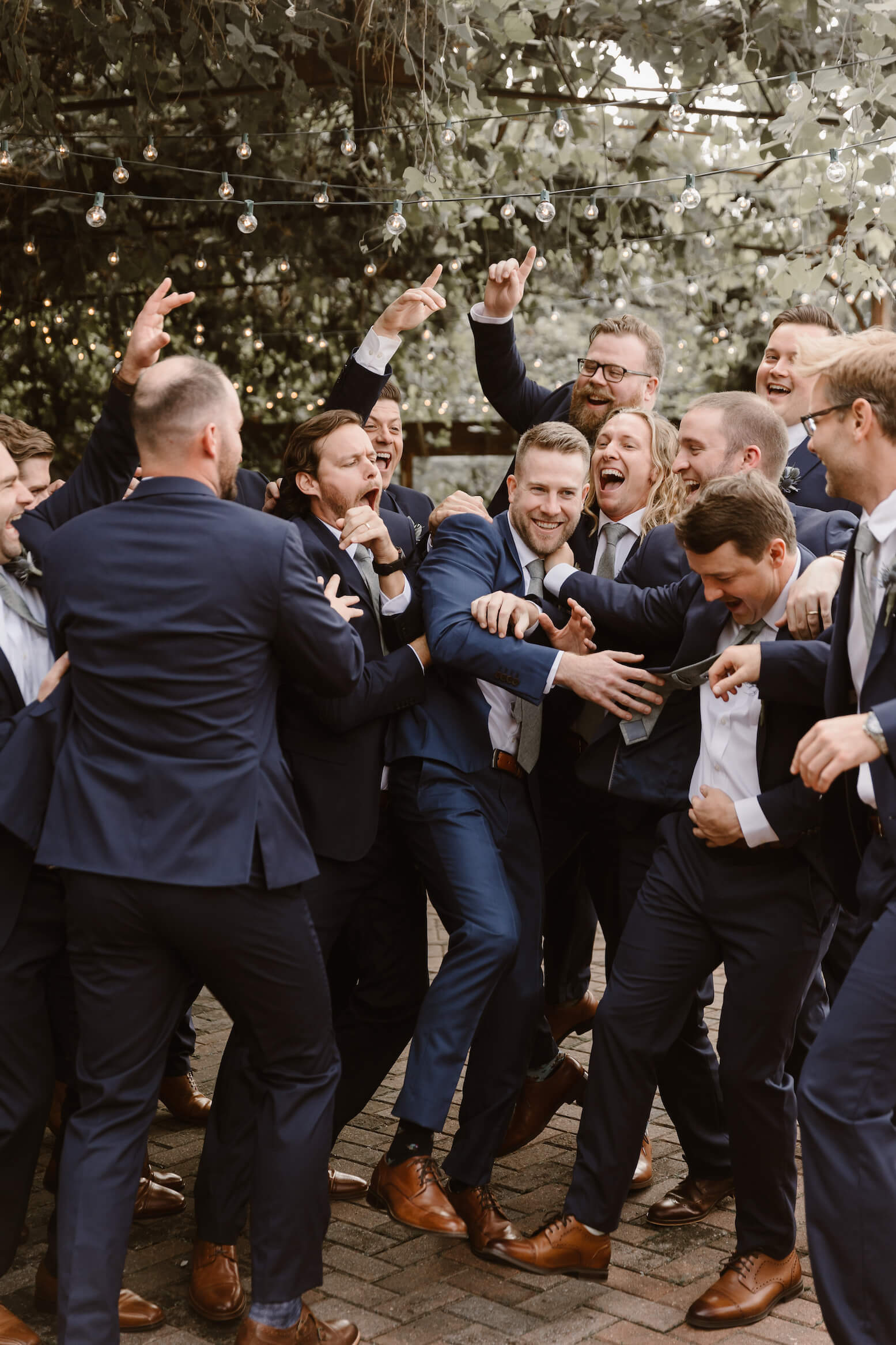 groomsmen surrounding groom and laughing at wedding in Tennessee
