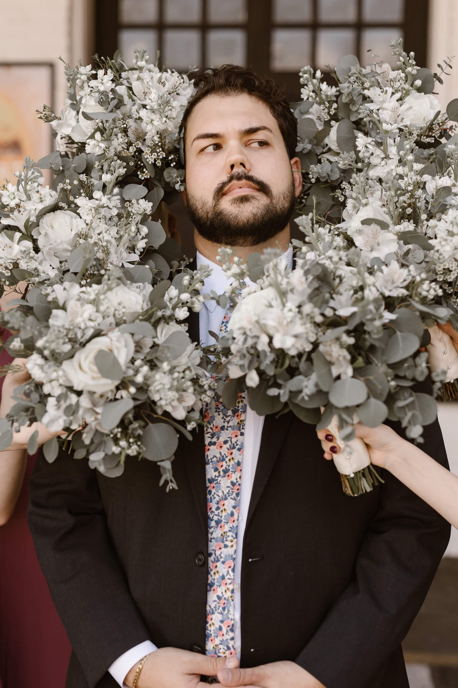 man surrounded by bridesmaid bouquets at same sex wedding in the Wedding Portfolio of Erin Morrison
