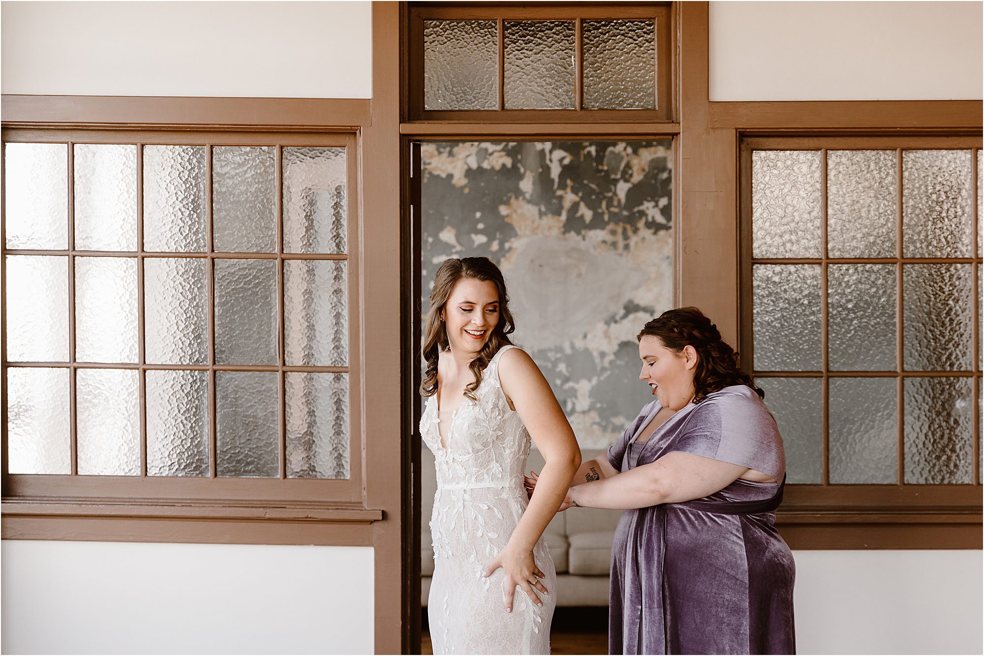 bridesmaid and bride get dressed in front of vintage door