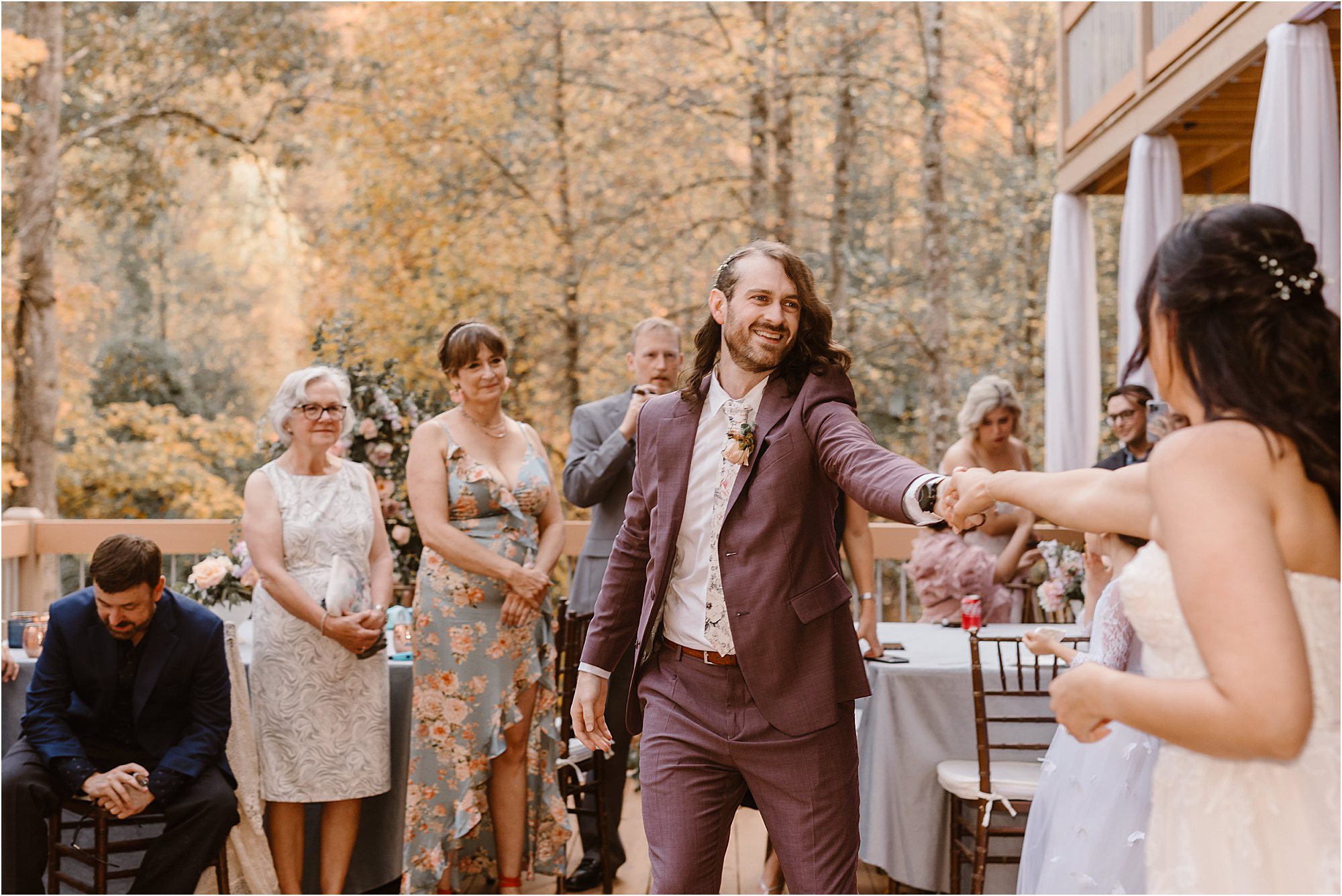 groom smiles and dances with bride at first look on cabin deck at Pigeon Forge Wedding