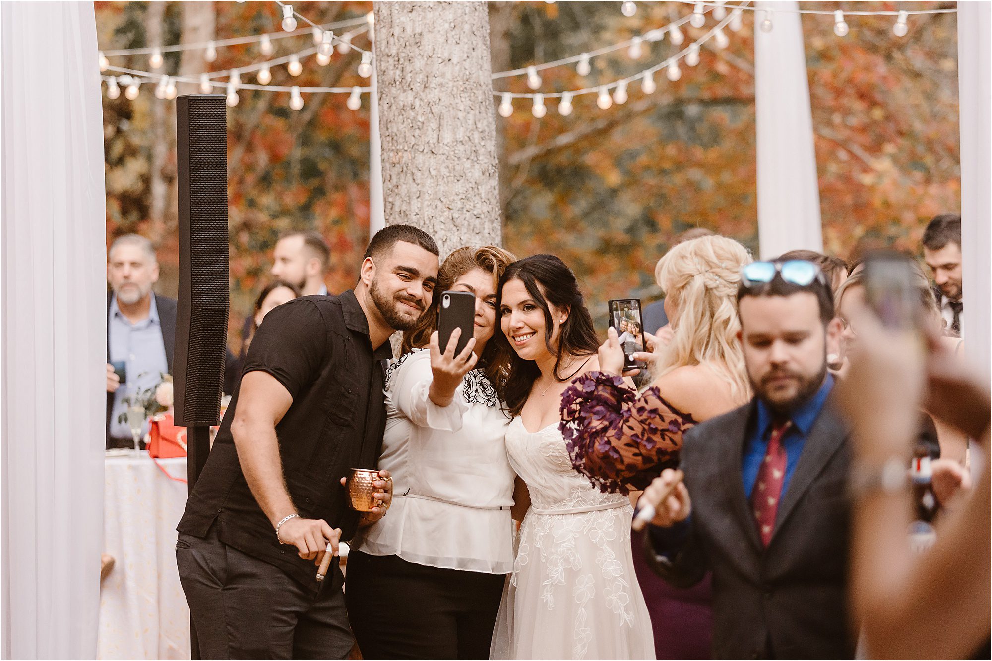 wedding guests take selfies with bride at wedding reception