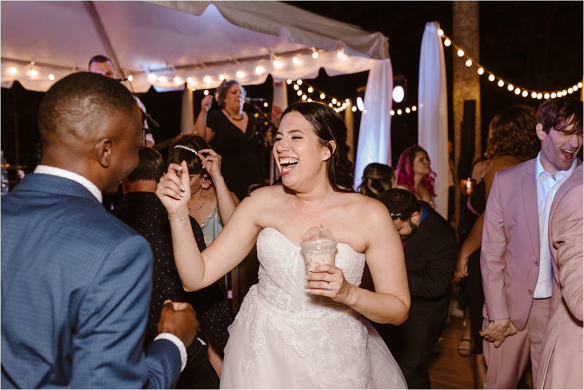 bride laughs with wedding guests at wedding reception