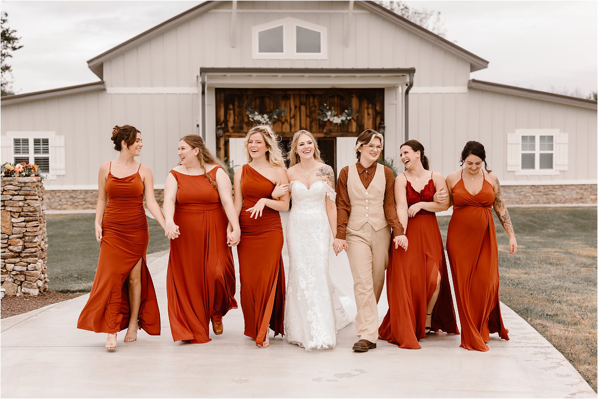 bride wtih friends in burnt orange bridesmaid dresses and suit