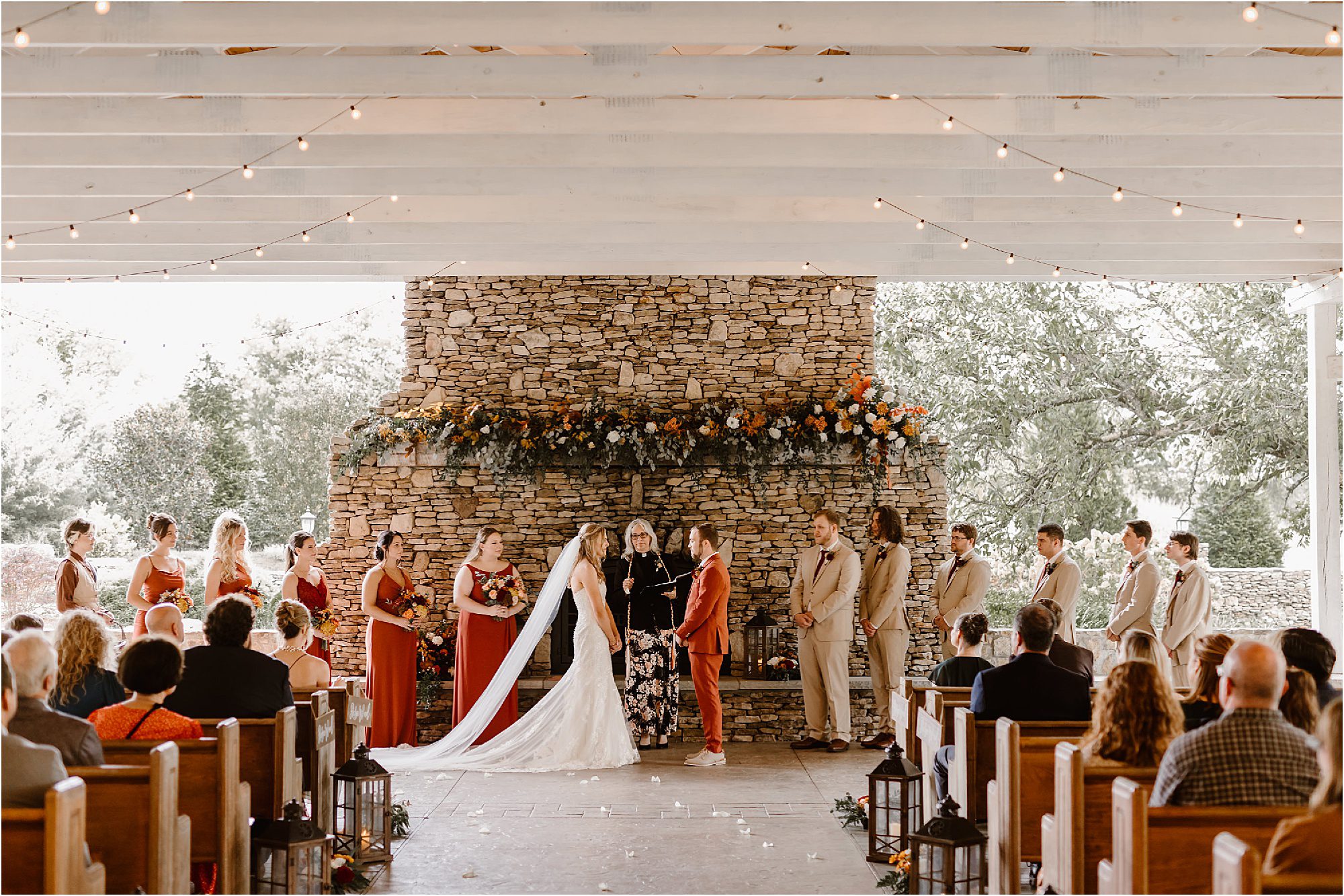 wedding ceremony in front of large stone fireplace at The Barn at Faith Farms