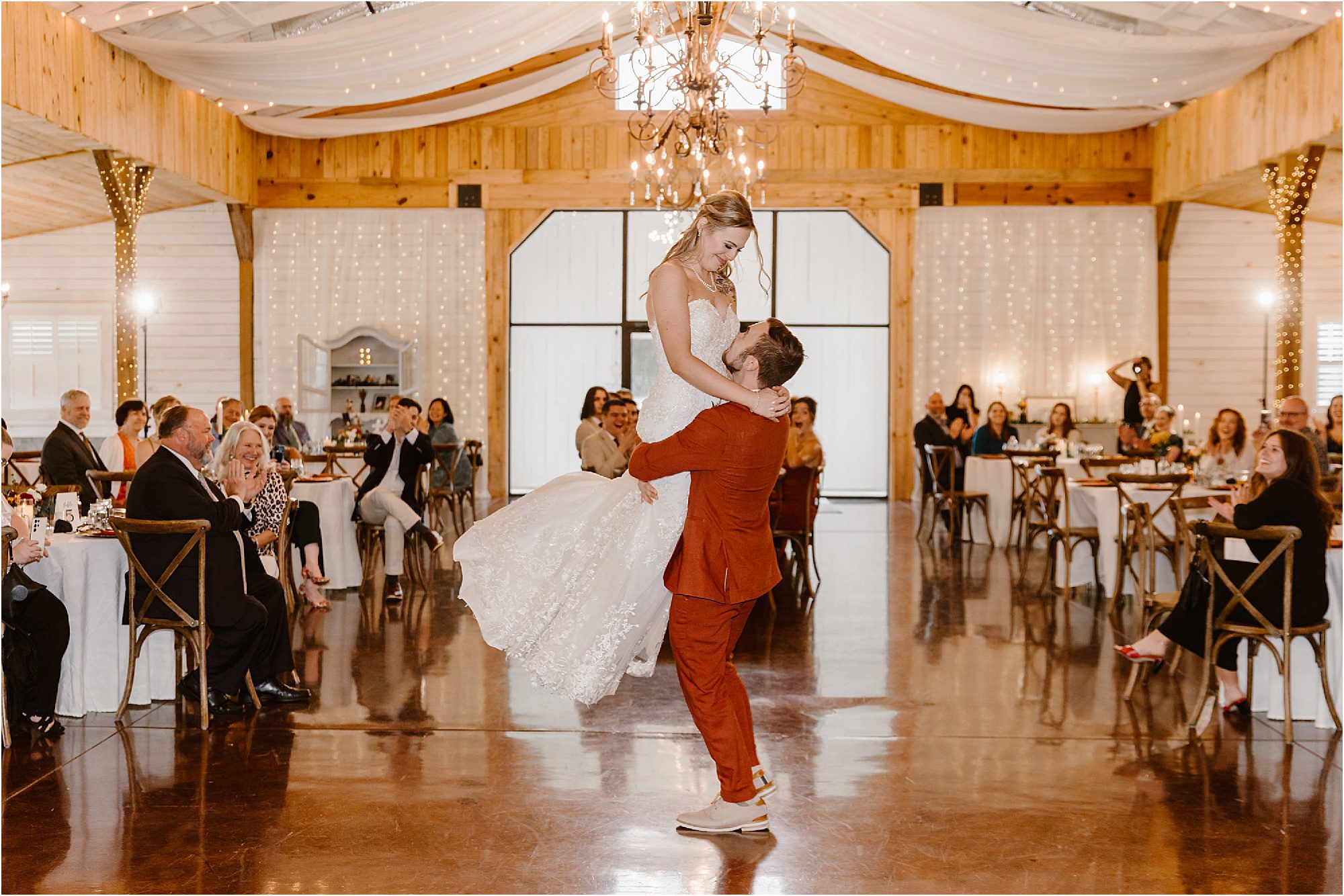 groom lifts bride during first dance