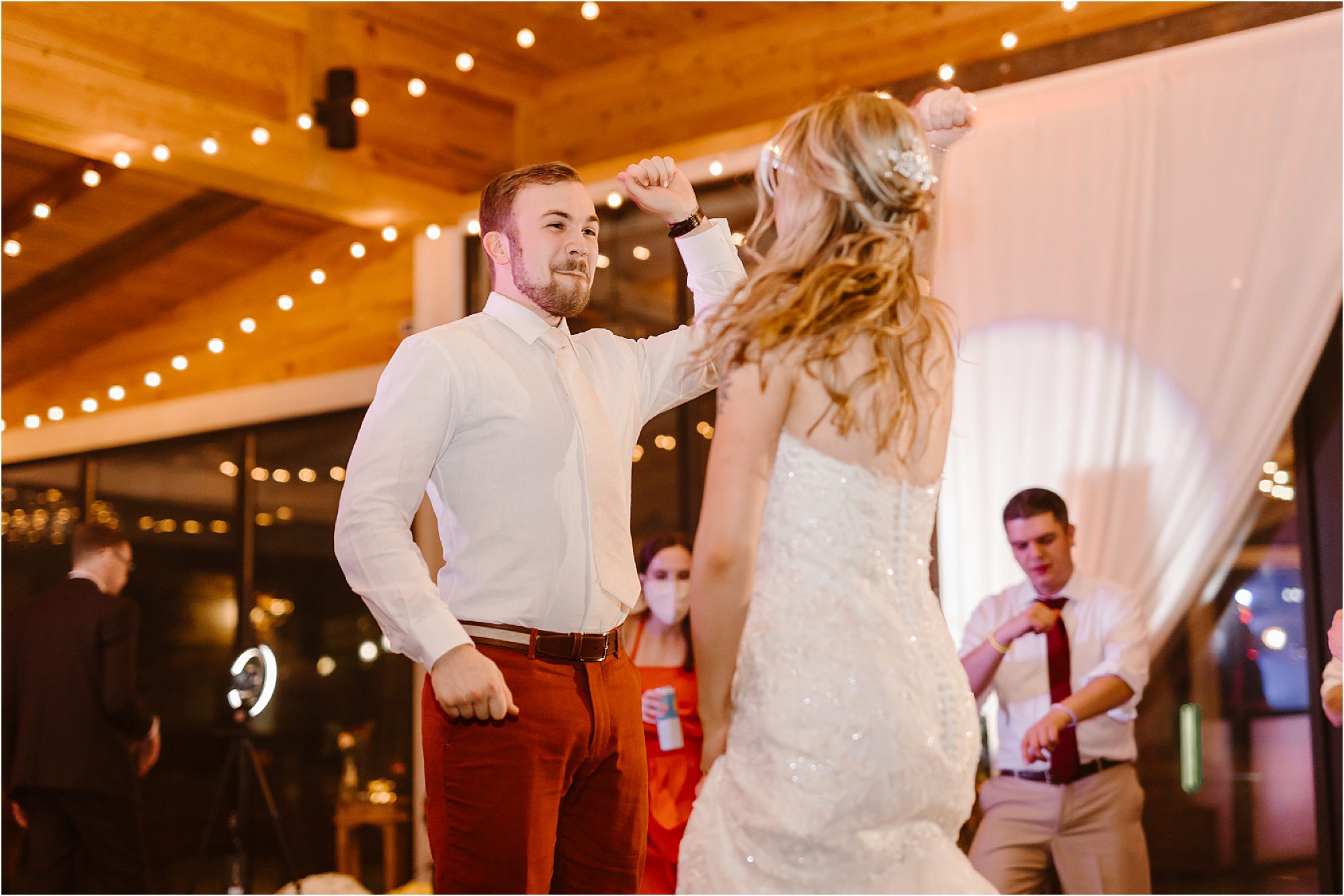 groom and bride jumping up and down at wedding reception dance floor