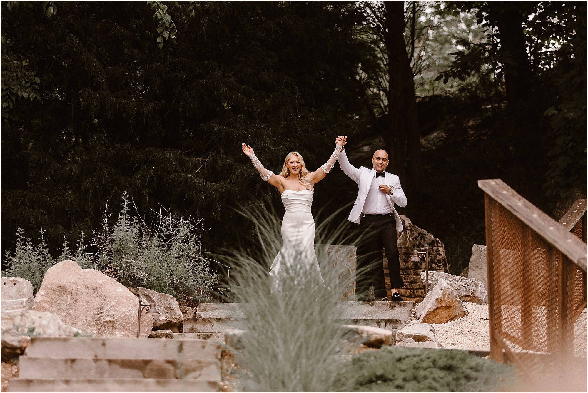 bride and groom celebrate while entering wedding reception