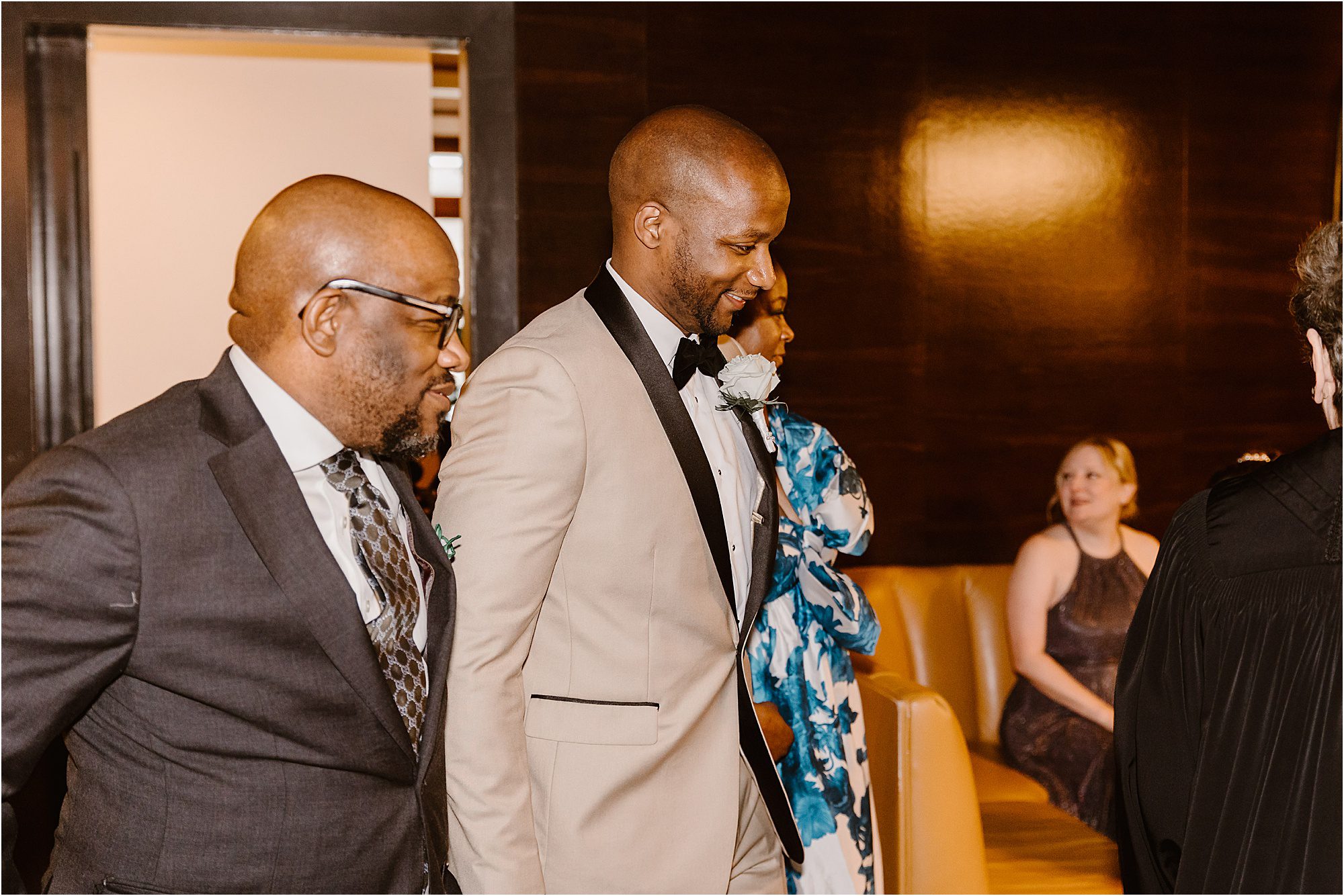 groom walking down aisle at wedding ceremony with mother and father