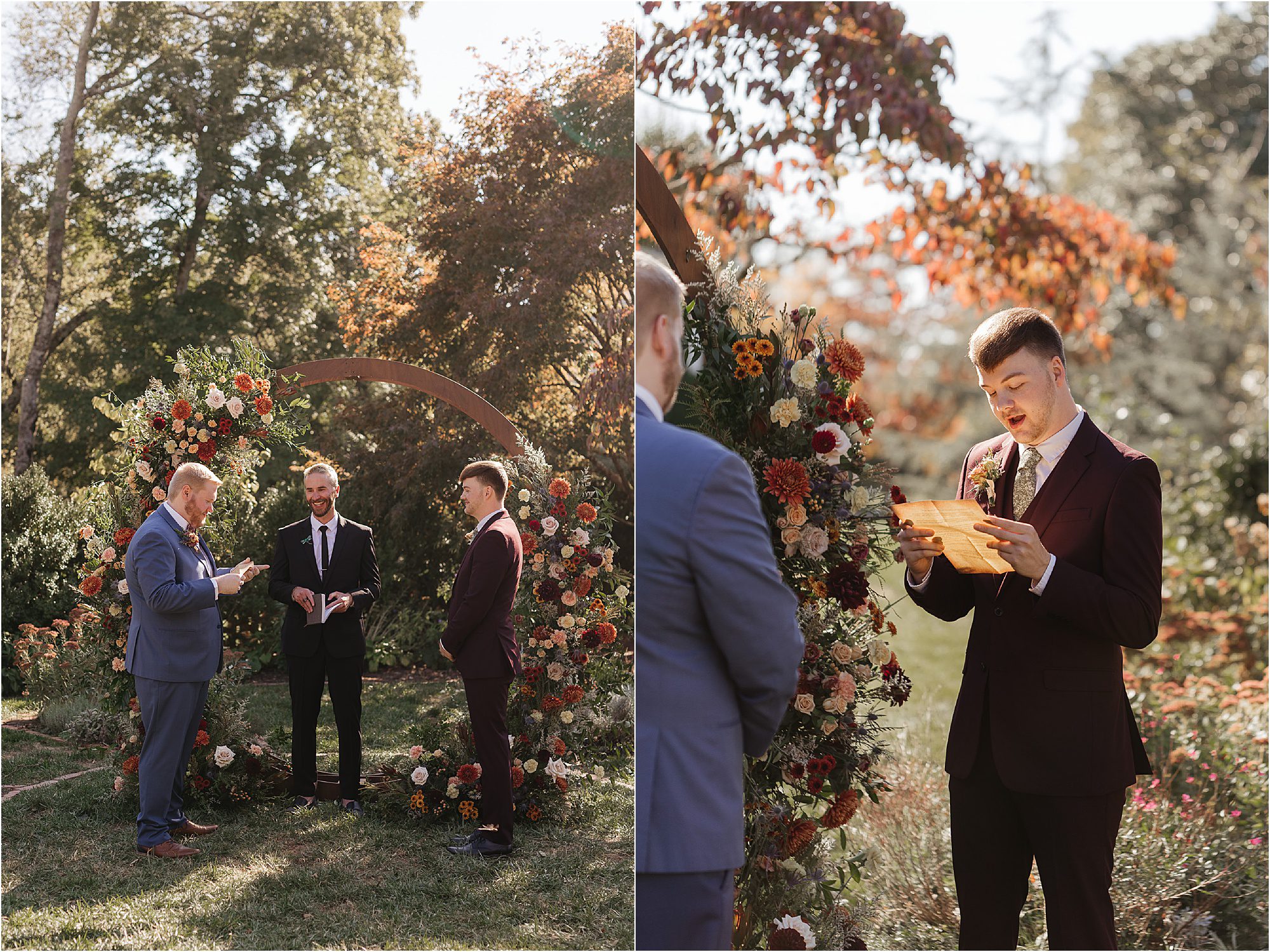 Two men stand under a floral arch during a Sunday wedding ceremony. One man in a suit reads from a document as sunlight filters through trees, highlighting the autumn foliage and vibrant flowers around them.