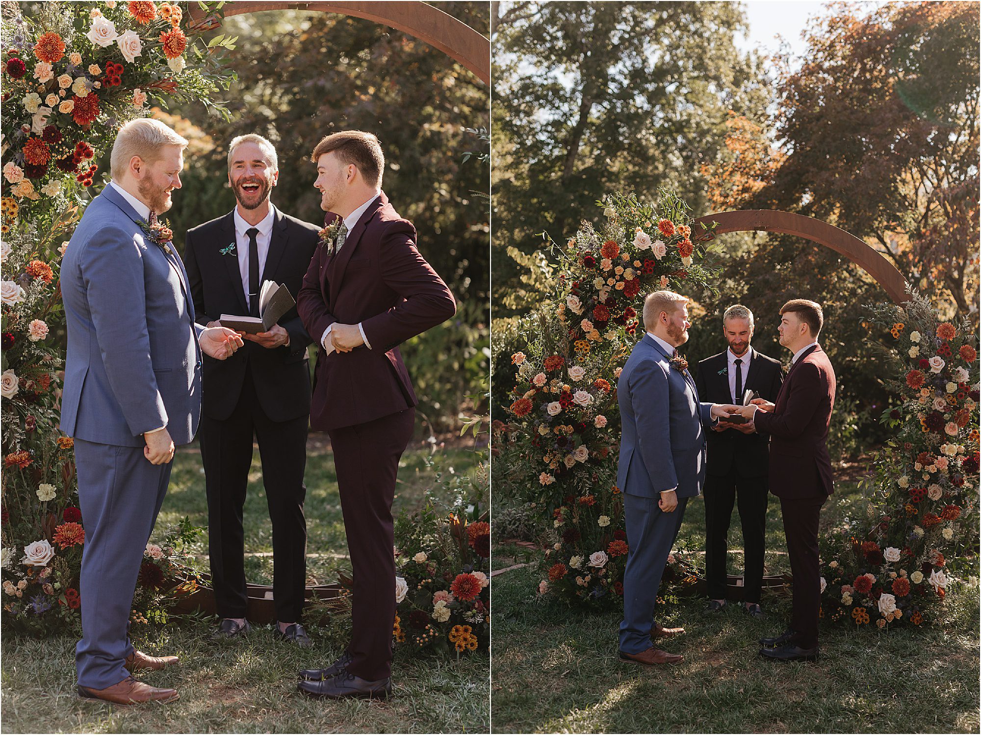 Two grooms stand facing each other on a sunny Sunday wedding ceremony outdoors, alongside an officiant. Behind them is a large arch adorned with colorful flowers, as sunlight filters through the surrounding trees.