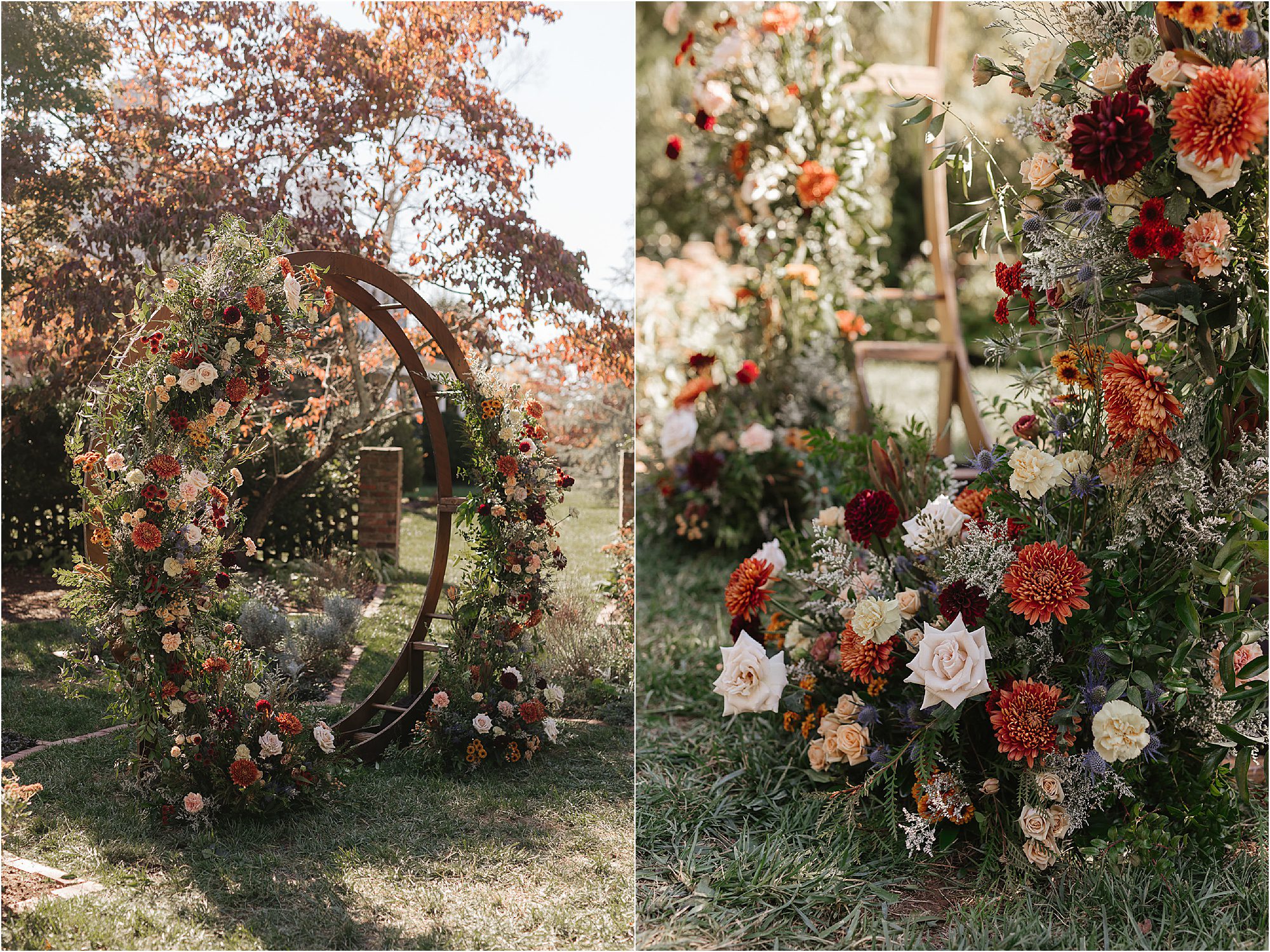 A lush outdoor Sunday wedding setup features a circular arch adorned with vibrant autumn flowers in shades of orange, red, and cream. The surrounding arrangements sit amongst green grass under a sunlit, leafy backdrop.