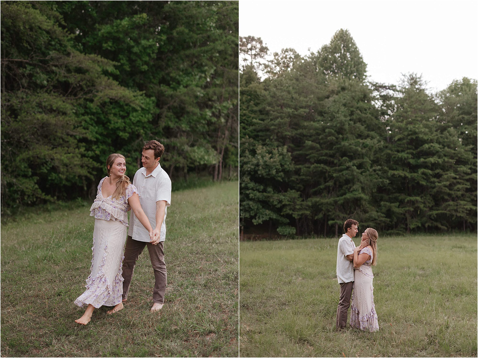 A couple stands barefoot in a grassy field near trees, holding hands and smiling at each other during their lakeside engagement session. The woman wears a white dress; the man wears a white shirt and brown pants. The setting is natural and serene.
